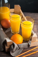 Fresh Orange Juice,Box of Fruit, Glass Bottle of Juice,Wooden Table,Dark background.