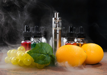 Electronic cigarette, lemons and bunch of grapes within vapor on black background