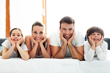Family of four lying on bed

