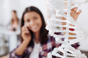 Charming clever student carefully examining the DNA model