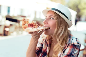 Crédence de cuisine en verre imprimé Pizzeria Jeune femme gaie appréciant la tranche de pizza