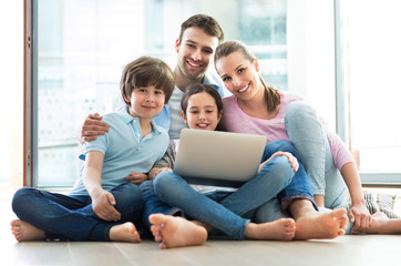 Happy family using laptop together
