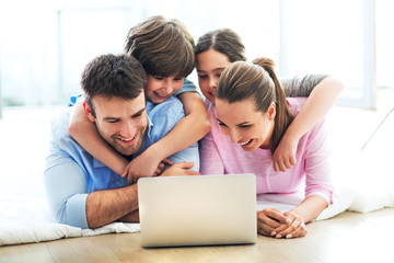 Happy family using laptop together
