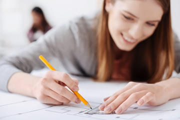 Gifted dedicated woman working on a blueprint drawing