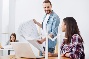 Obraz premium Lively motivated engineers chatting about details of their eco project