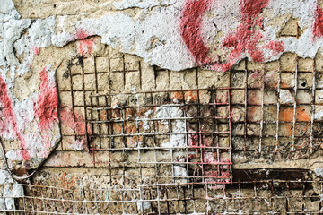 старая разрушенная стена с металлической решеткой 