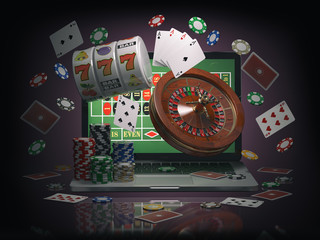 Online casino concept. Laptop with roulette, slot machine, casino chips and playing cards isolated on black background.
