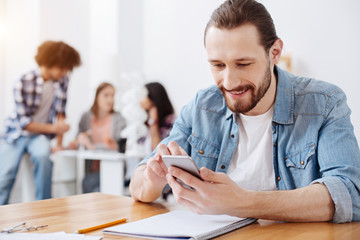 Obraz premium Sociable charismatic man chatting with friends online