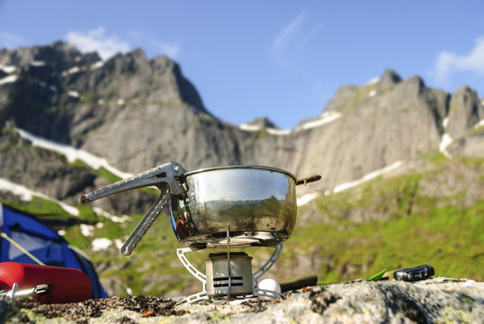 A portable gas burner on a rock in Lofoten, Norway, in front of Nonstinden and Sautinden.