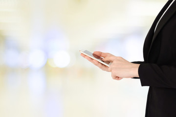 Business woman hands using smart phone over blur office with bokeh light background, banner, business on phone