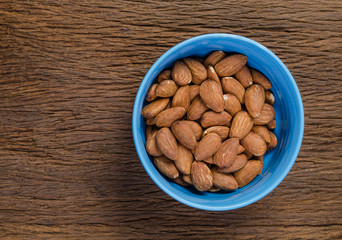 almond in blue porcelain bowl on wooden board