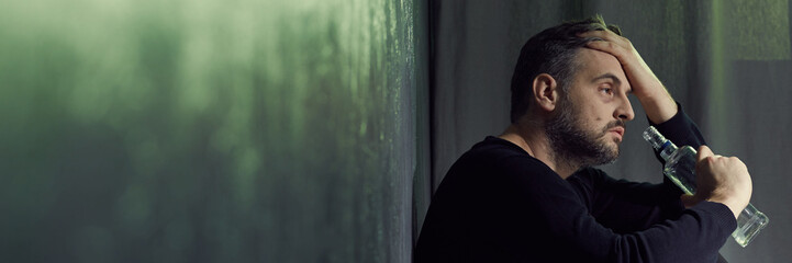 Drinker with bottle of alcohol