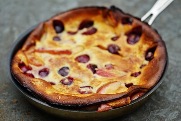 Peach and cherry Dutch pancake clafoutis in a pan 