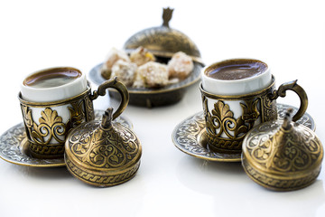 Turkish coffee with delight and traditional copper serving set on white background