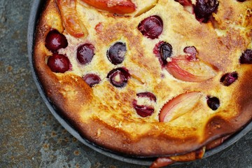Peach and cherry Dutch pancake clafoutis in a pan 