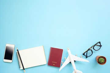 Flat lay design of work desk Planning with plane, notebook pencil passport and glasses on blue...