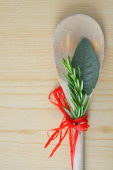 Sage and rosemary on wooden kitchen table, vertical