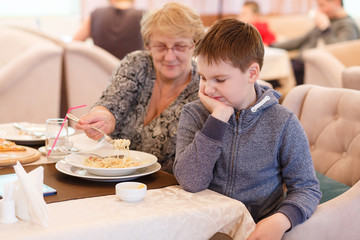 Preteen handsome boy with a plate of pasta refuse to eat