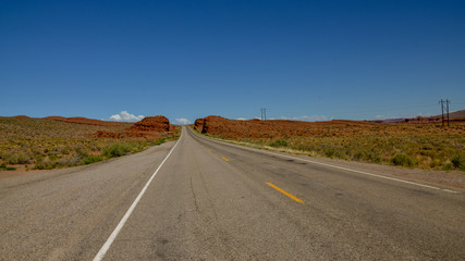 Fototapeta na wymiar empty road in desert between Arizona and Utah U.S. Route 163 National Scenic Byway, Mexican Hat, San Juan County, Utah, United States