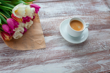 the bouquet of tulips is wrapped in a paper isolated on a wood background
