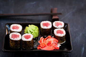 Fresh delicious tuna maki sushi rolls on dark background
