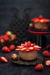 Obraz na płótnie Canvas Mini chocolate cheesecake dessert decorated with fresh strawberries