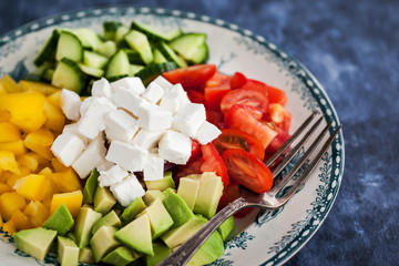 Delicious tomato, bell pepper, cucumber, avocado, onion and feta salad