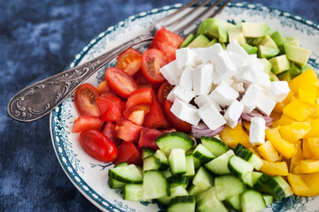 Delicious tomato, bell pepper, cucumber, avocado, onion and feta salad