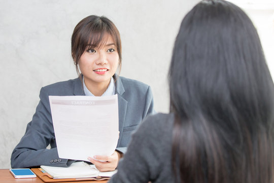 Young Asian woman arriving for a job interview. Business people takling in modern office. Greeting deal concept