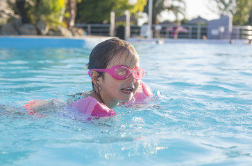 Little girl enjoying the summer at swiming pool