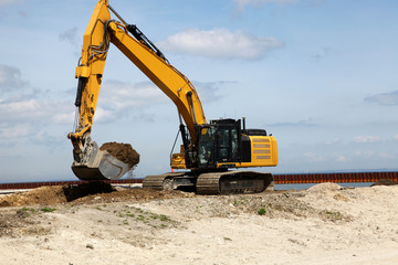 Fototapeta na wymiar Excavator works on a construction site with excavation