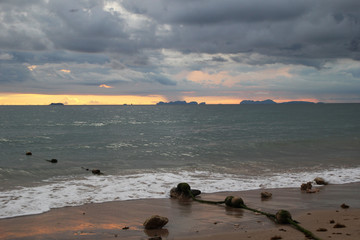 Fototapeta na wymiar Travel to island Koh Lanta, Thailand. The view on the sand beach and cloudy sky at the sunset.