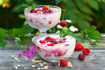 yogurt with muesli and raspberries in two glass bowls