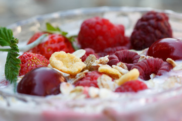 Healthy Breakfast of muesli, yogurt, raspberries and other berries. Dieting concept, closeup.