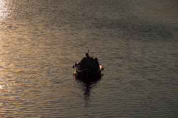 boating floating down river during sunset