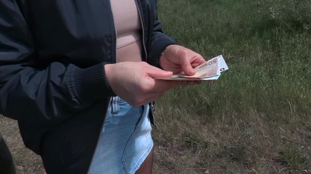 Prostitute with euro banknotes near car on the road