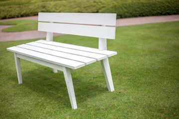 White bench with green grass