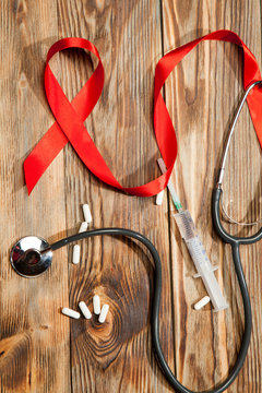 Red ribbon awareness on old aged wood background: World aids day symbolic concept / concerns/ help and campaign on people health public support on HIV, day cancer.