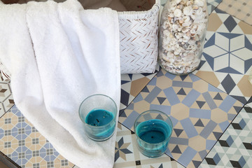 suelo de baño con velas, botella con conchas y cesta