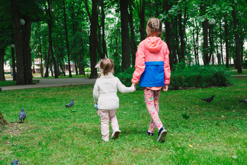 Children walk in the park on a day off. The sun is shining