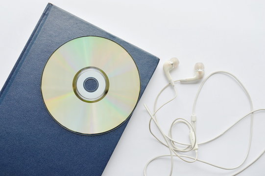 book and CD- rom with earphones on white background