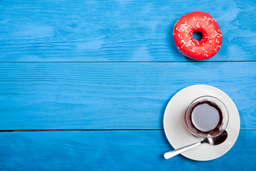 Obraz na płótnie Canvas Cup of tea and donuts on a blue wooden table