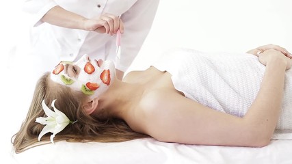 beautiful young girl getting a mask care facial skin with fresh fruit