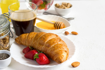 Healthy breakfast set: croissant, berries, and coffee. Selective focus and copy space