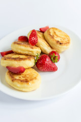 Delicious curd fritters with strawberry on a white plate