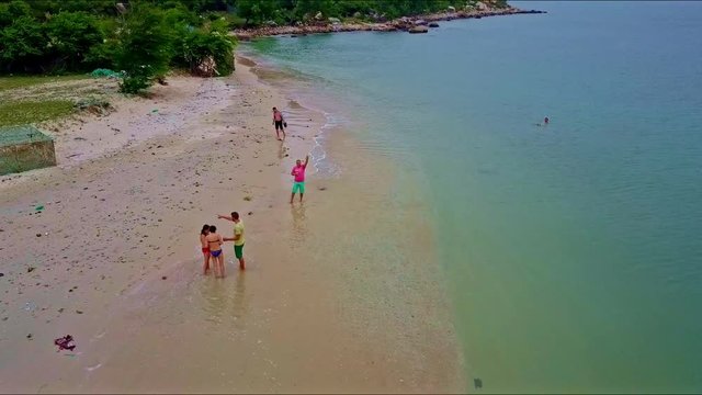 Drone Camera Moves Closely to People on Beach and over Sea