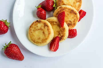 Delicious curd fritters with strawberry on a white plate