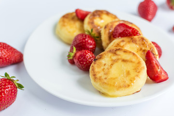 Delicious curd fritters with strawberry on a white plate