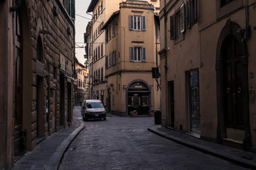 Fototapeta na wymiar Narrow street and buildings with parked white van in Florence Italy, at dawn.