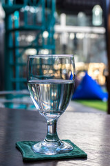 Glass of water on a wooden table in a restaurant. Bali island.